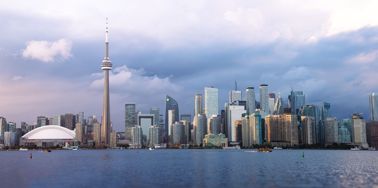 Beautiful view of Toronto skyline with the iconic CN Tower during sunset, showcasing urban architecture.